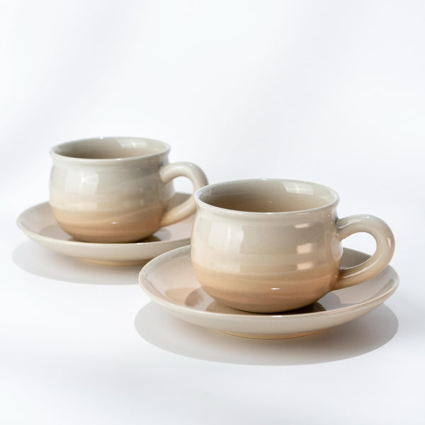 Pair of Hagi ware coffee cups and saucers in soft pink-cream glaze with fine crackle