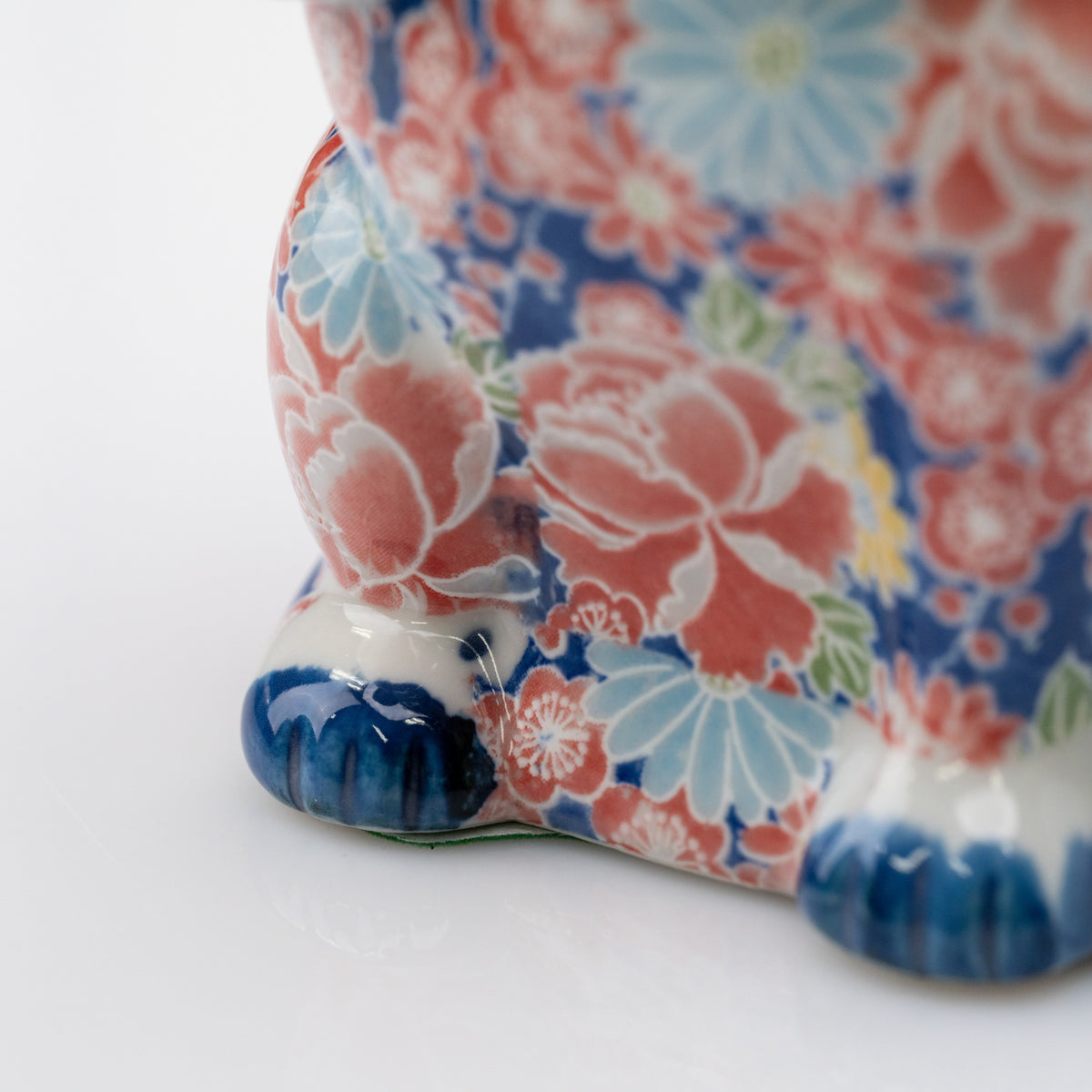 Détail de fleurs roses et bleu pâle à côté de la patte bleue du chat