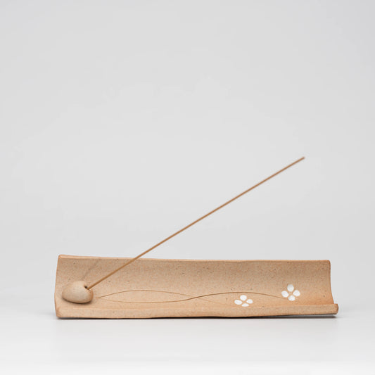 Brown floral incense holder, side view showing the shape and surface.
