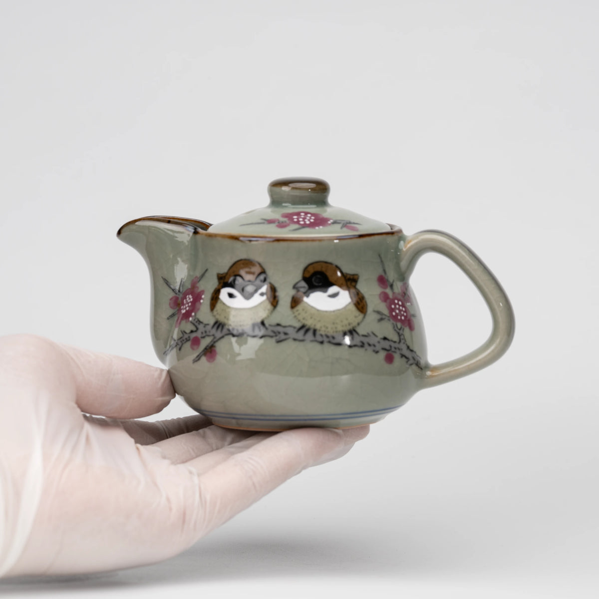 Sparrow teapot, held in a hand to show scale.