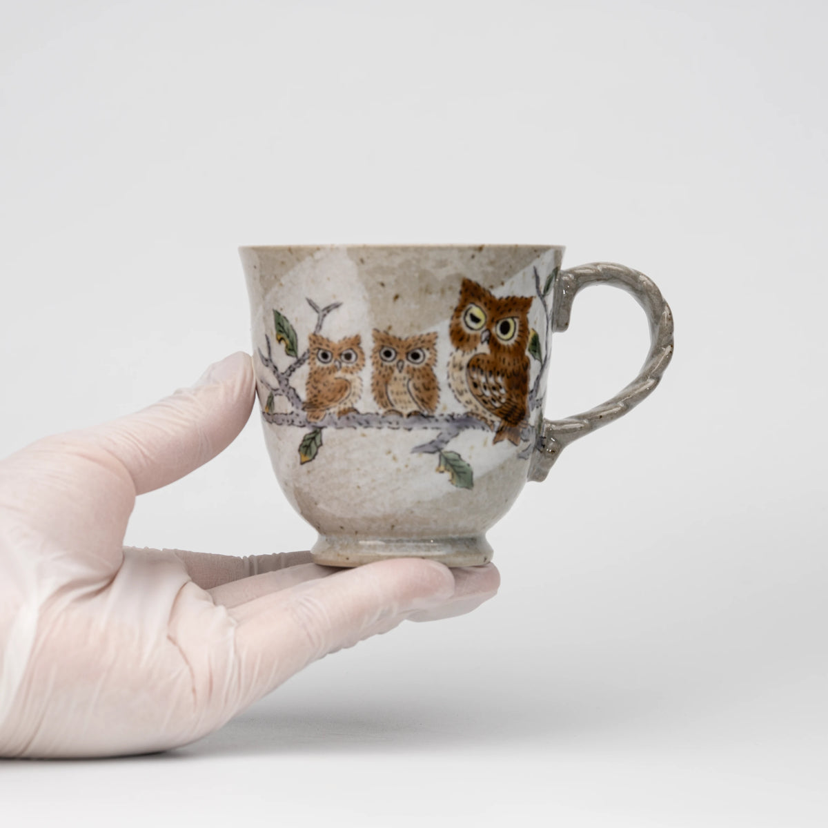 Three owls mug, held in a hand to show scale.