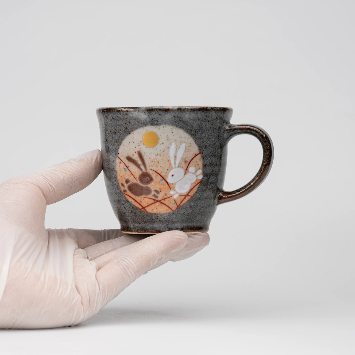 Rabbit motif mug, held in a hand to show scale.
