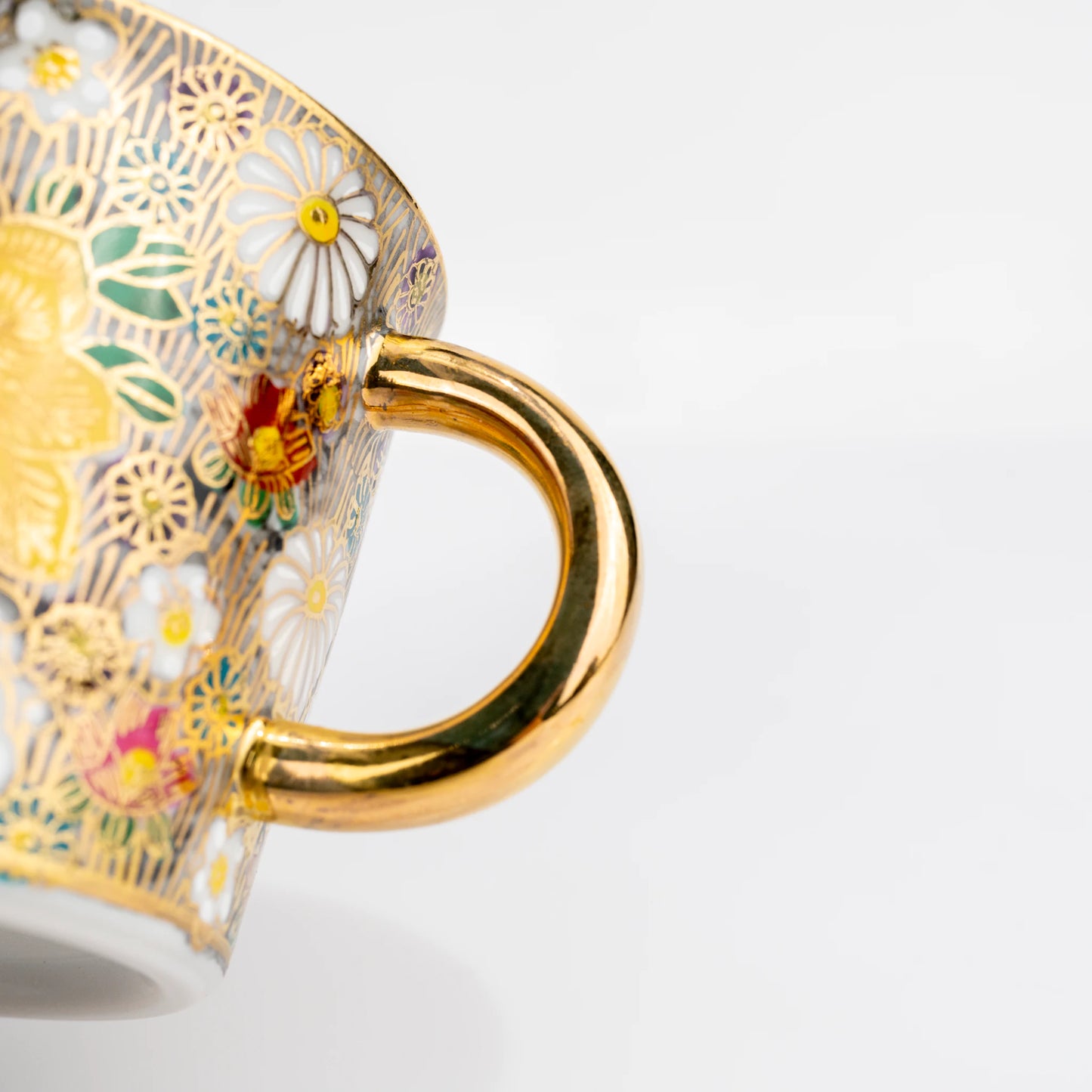 Close-up side view of Kutani cup handle and floral decoration