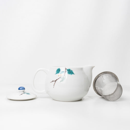 Angled view of Kutani bird teapot with blue lid knob
