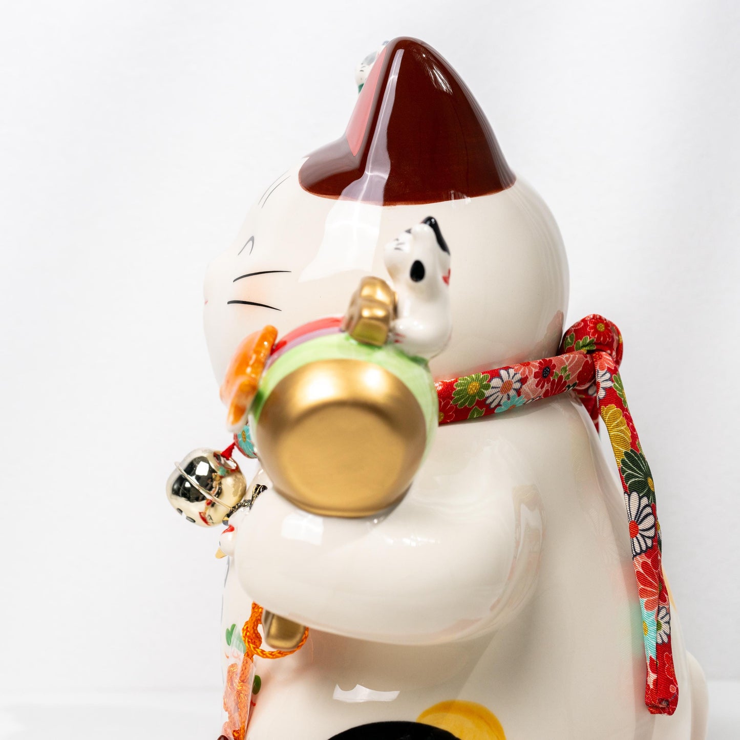 Full display view of large beckoning cat ornament on red base