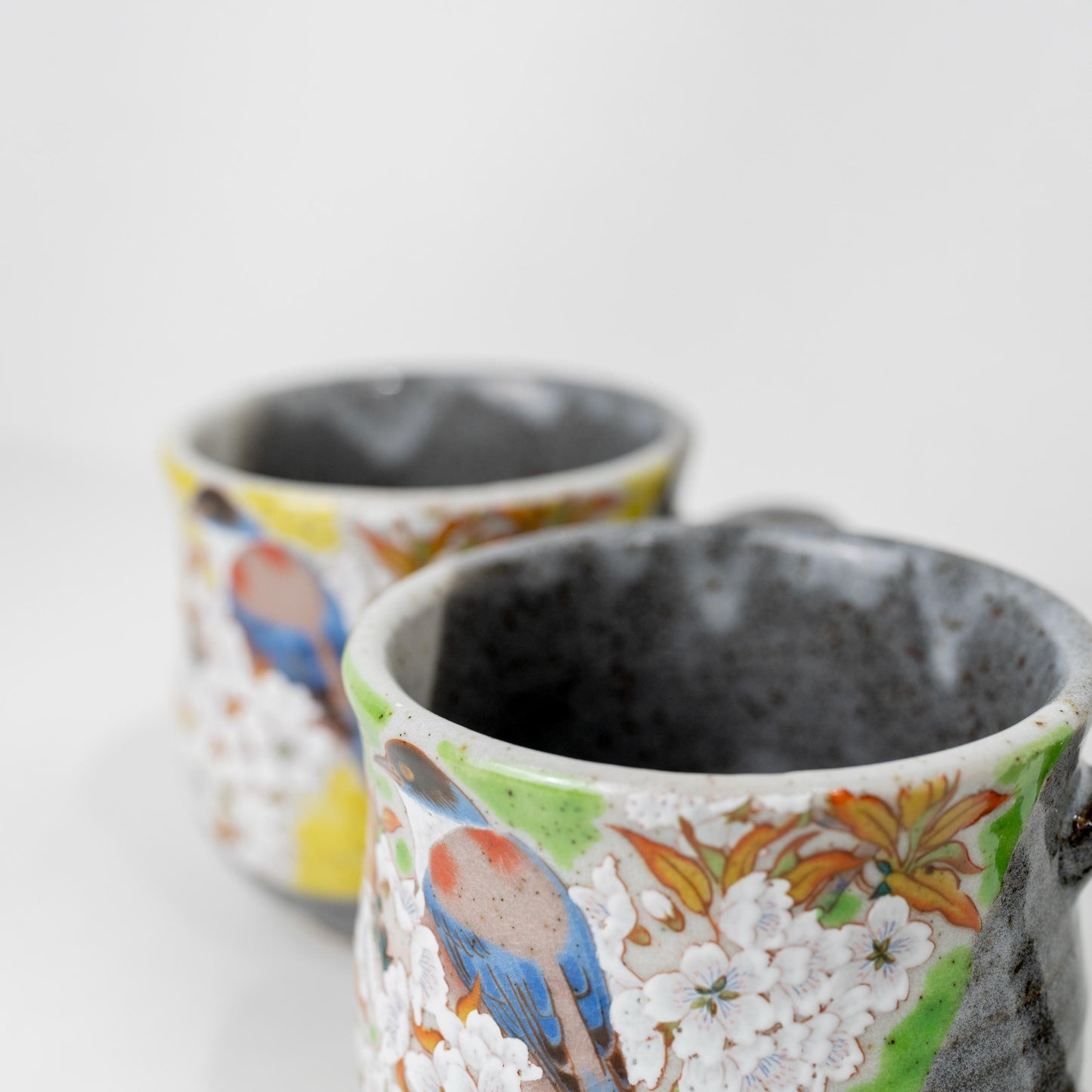 Top-front view of Kutani mug pair showing interior and painted rims