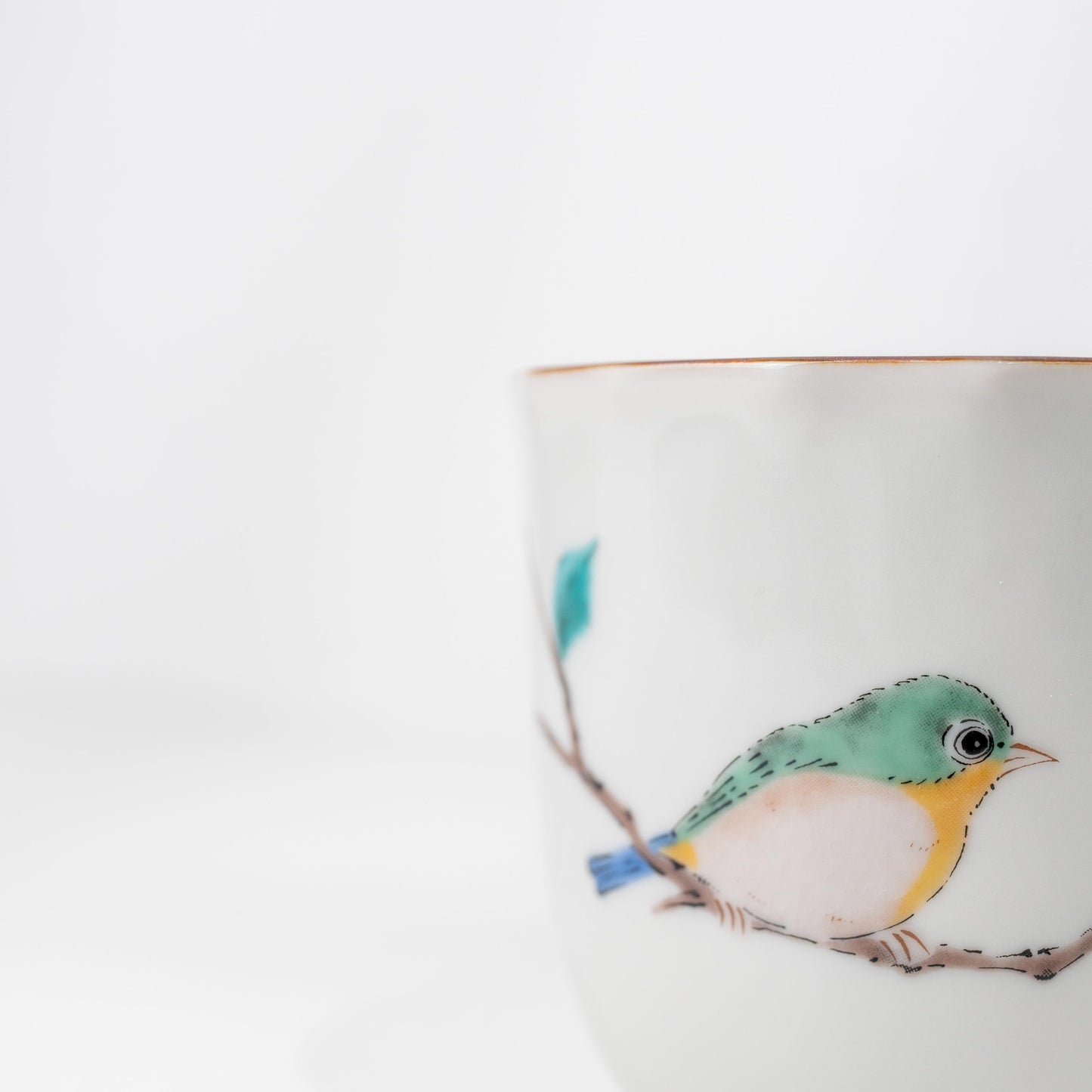 Front angle of Japanese porcelain bird mug on white background