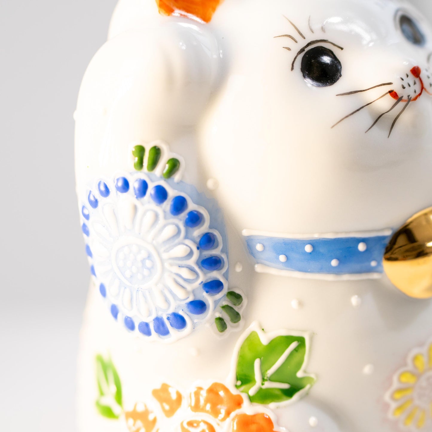 Close-up of face and collar on Kutani lucky cat