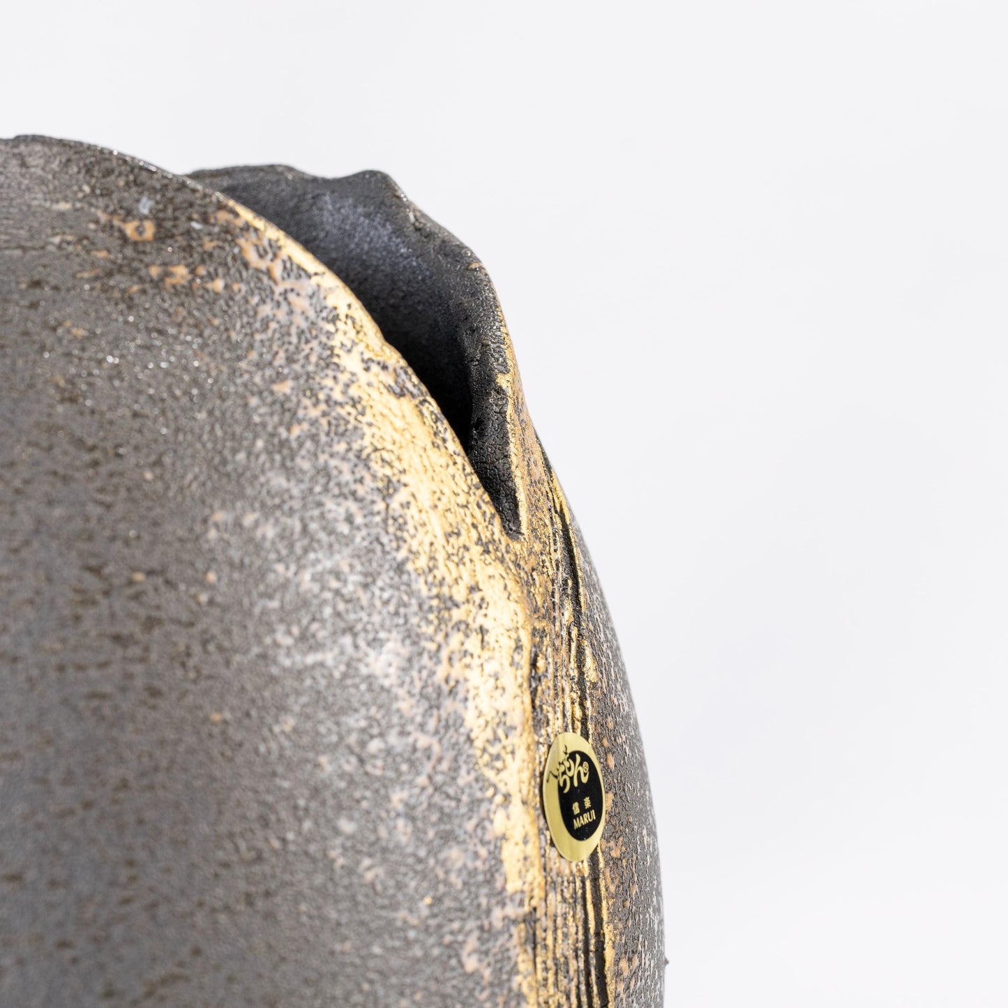 Close-up of gold brush detail on black Shigaraki vase