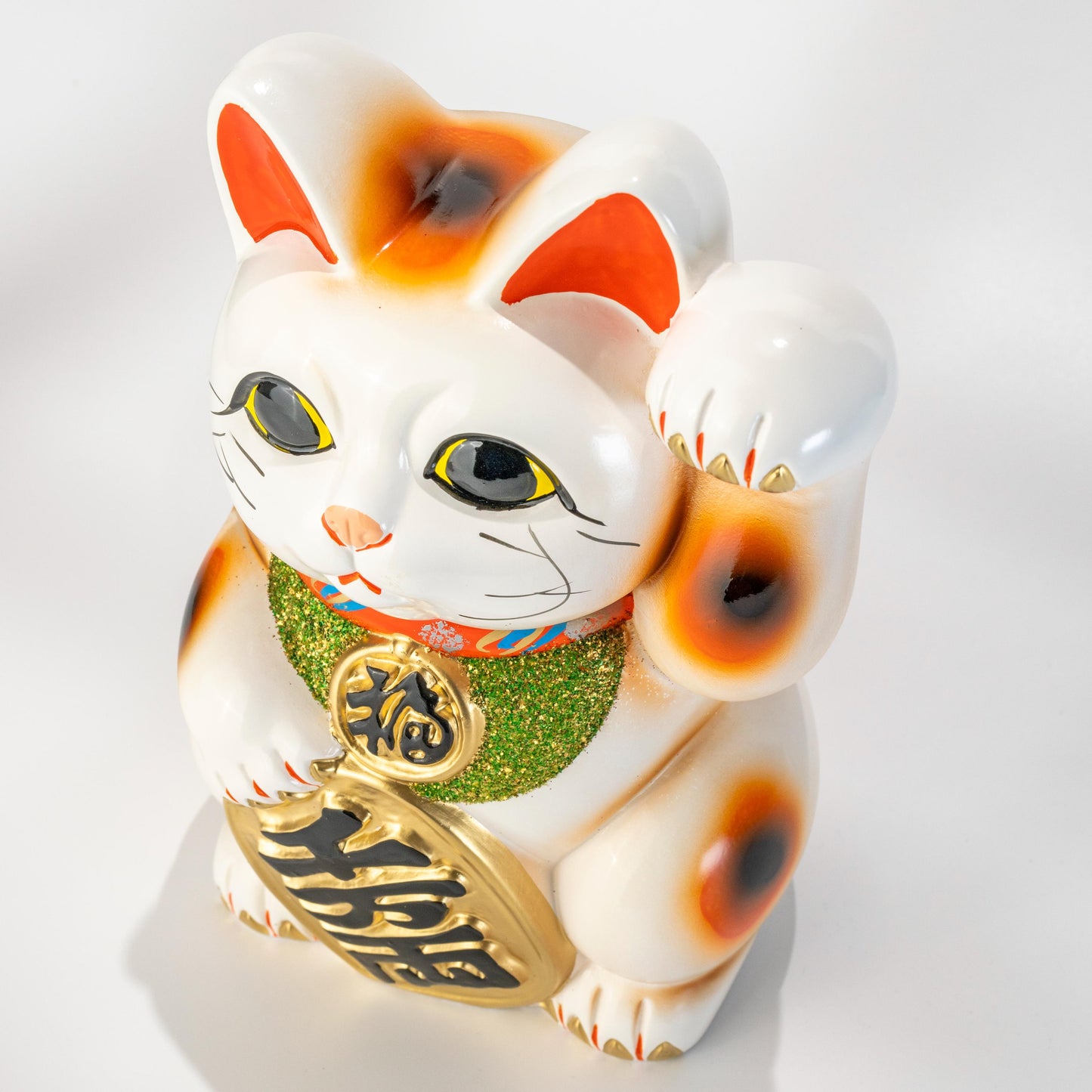 Three-quarter view of Tokoname ceramic lucky cat with left paw raised