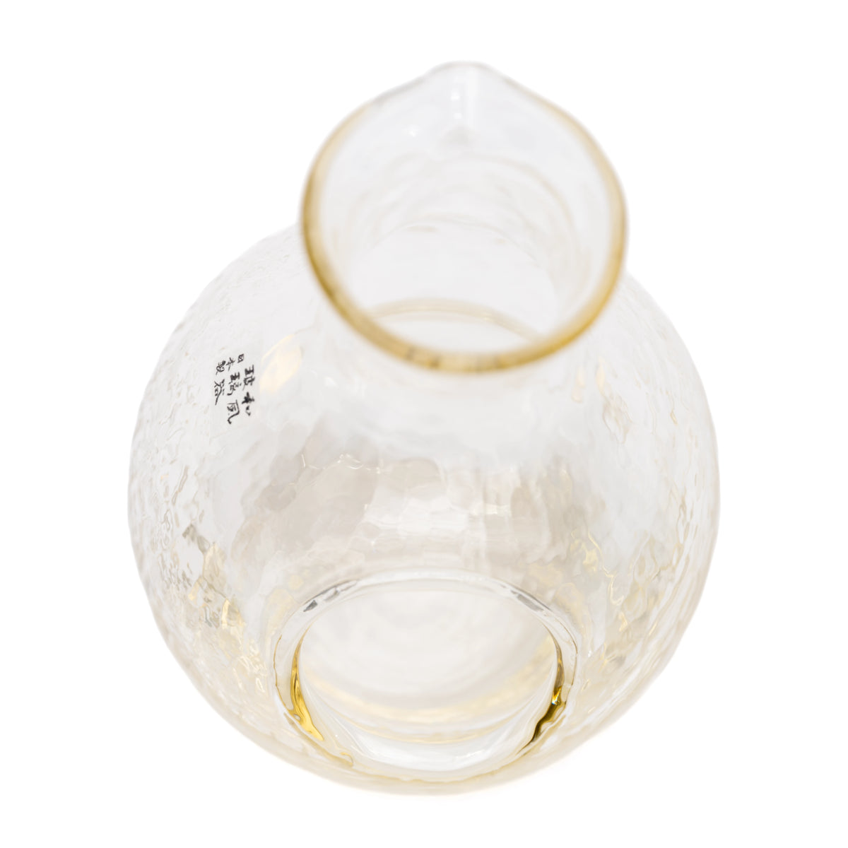 Top view into the glass sake carafe and its round interior.
