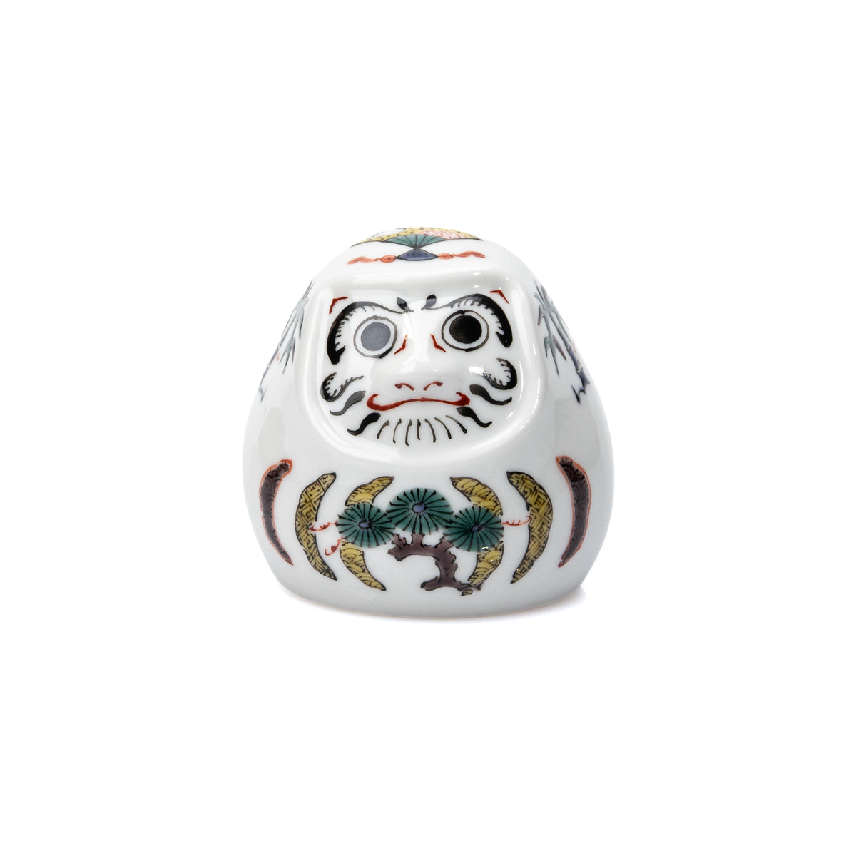 Front view of the white daruma's face and pine decoration.