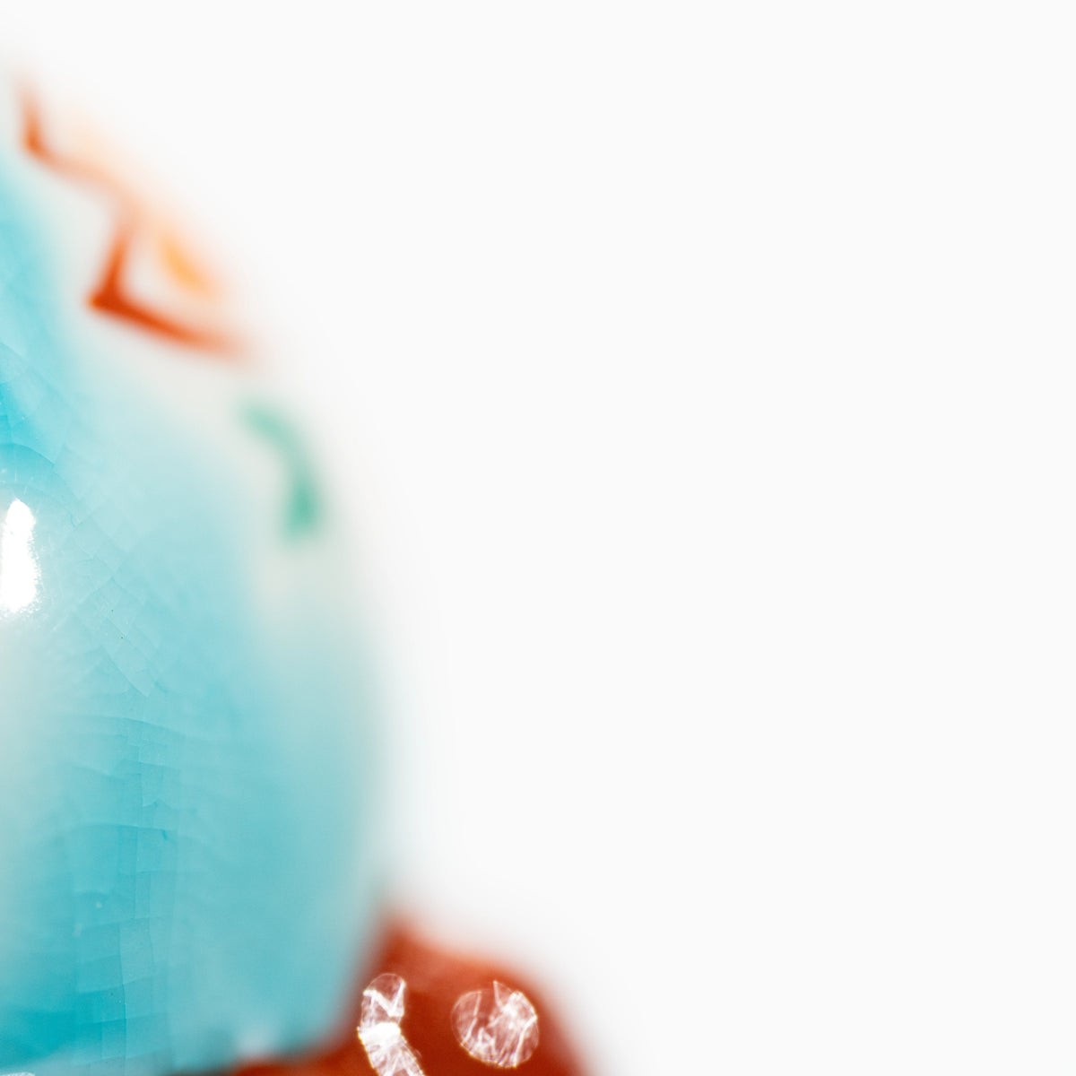 Close-up of the turquoise glazed cat's raised paw.
