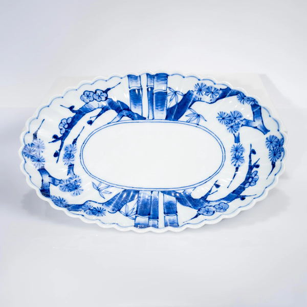 Original product photograph of the Arita oval platter with a scalloped rim and blue pine, bamboo and plum decoration.