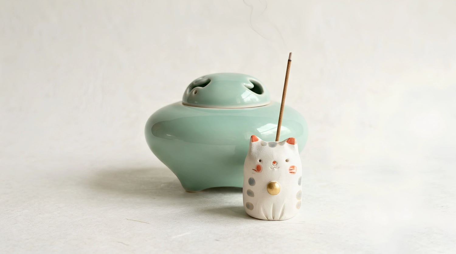 Un brûle-encens et un porte-encens japonais regroupés en petit au centre sur du washi.