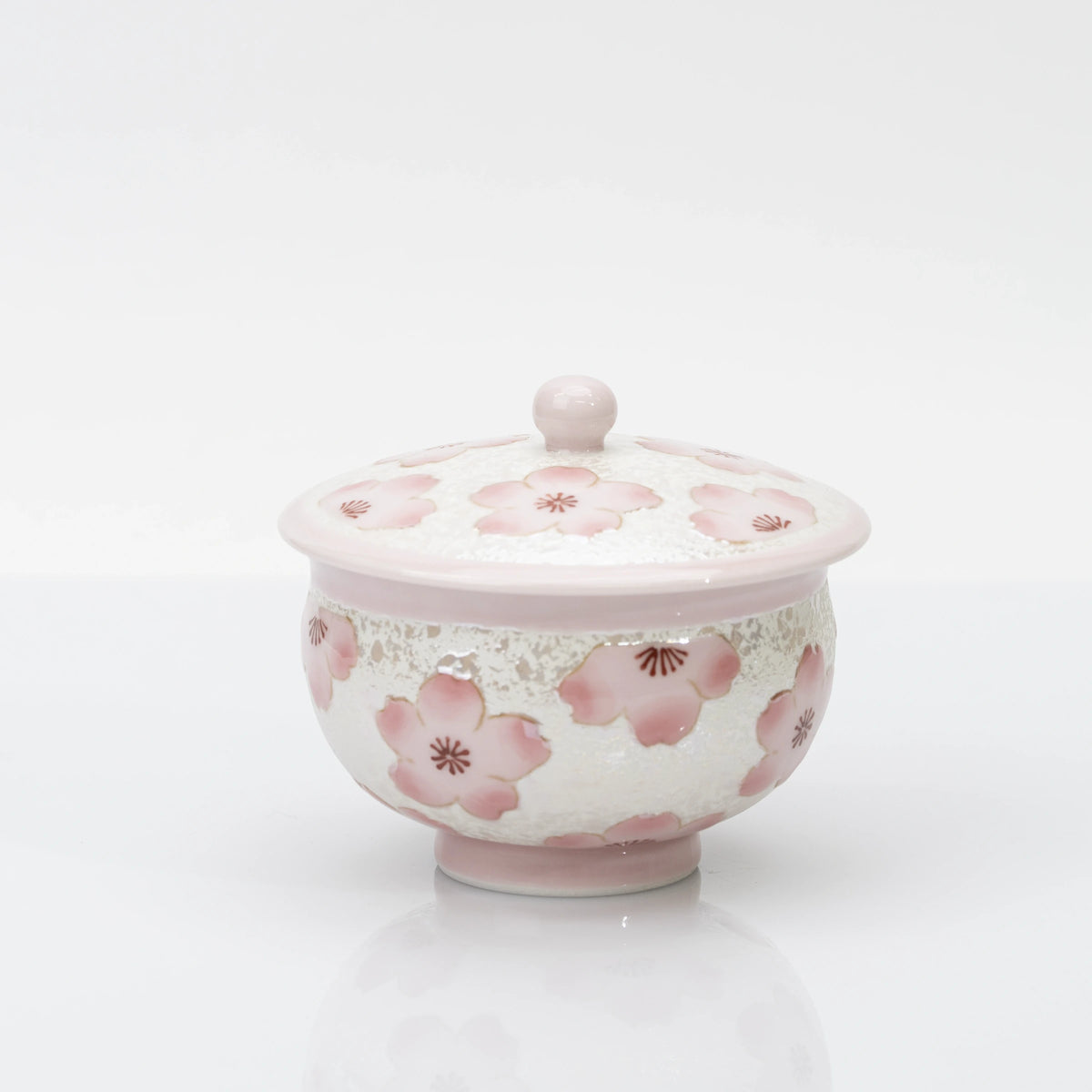 Pink cherry blossom teacup with matching lid, a pearly white finish, and a pale pink rim, foot, and rounded lid knob.