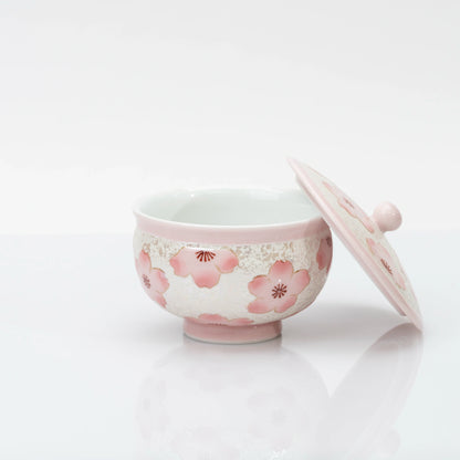 Open cherry blossom teacup with its matching lid leaning beside it, revealing the plain white interior.