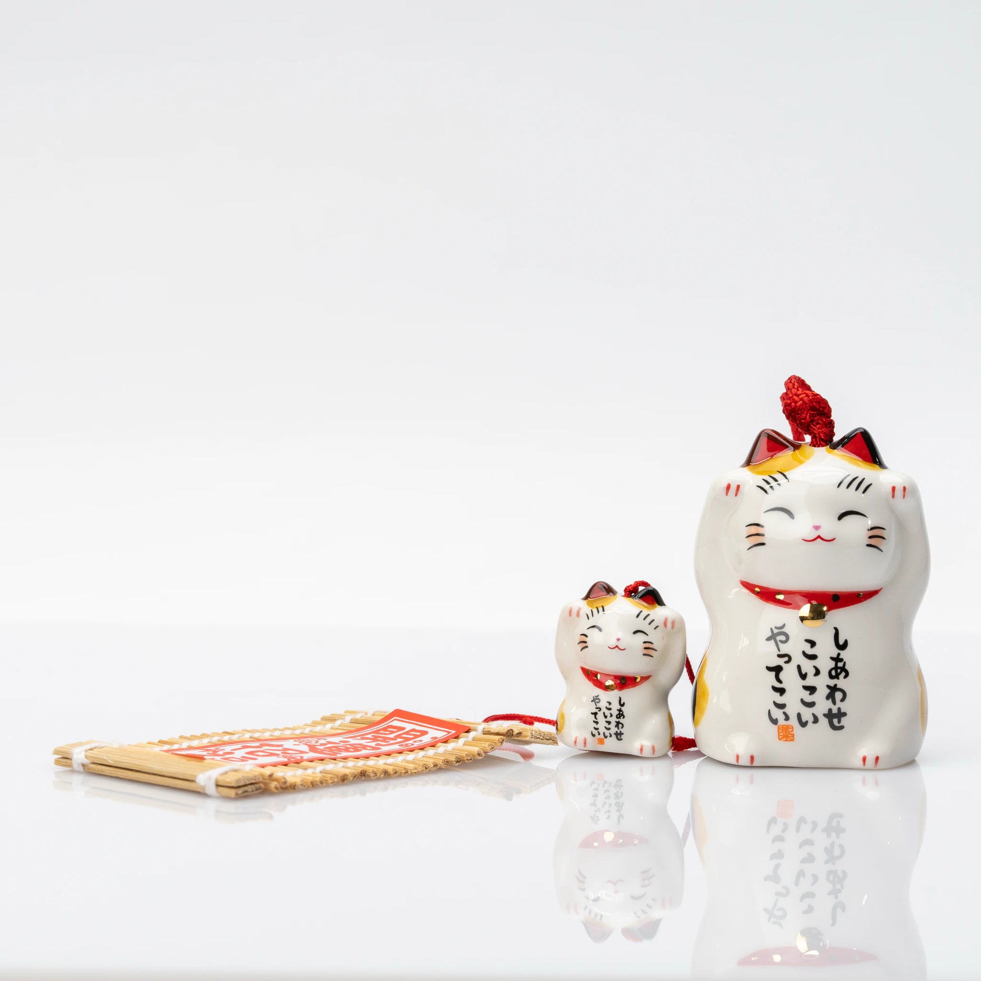Front of the parent cat bell, brushed in three columns with しあわせ こいこい やってこい