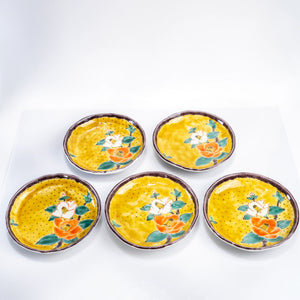 Top view of five Kutani yellow-ground camellia dessert plates arranged together