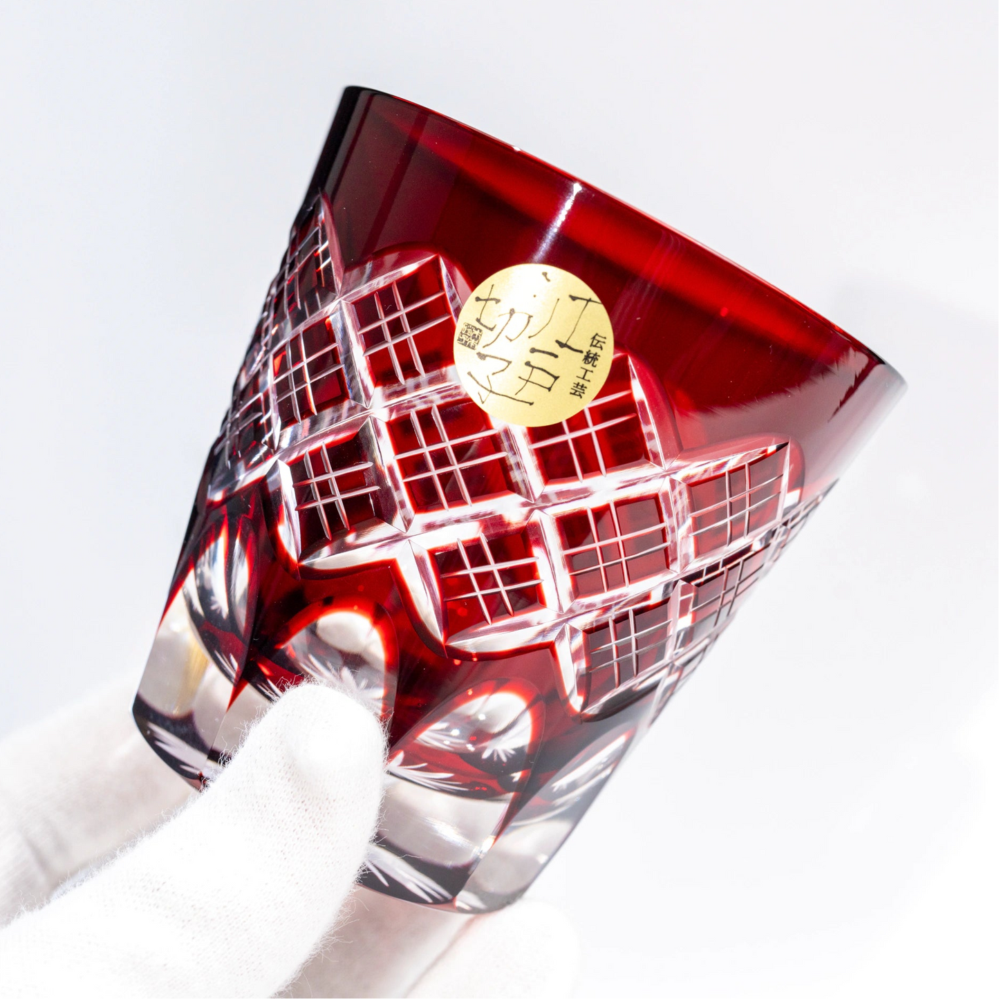 Red Edo Kiriko old glass held at an angle showing layered cut pattern