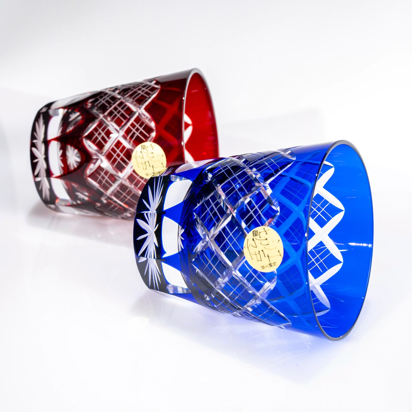 Red and blue Edo Kiriko tumblers laid on their sides, side angle view