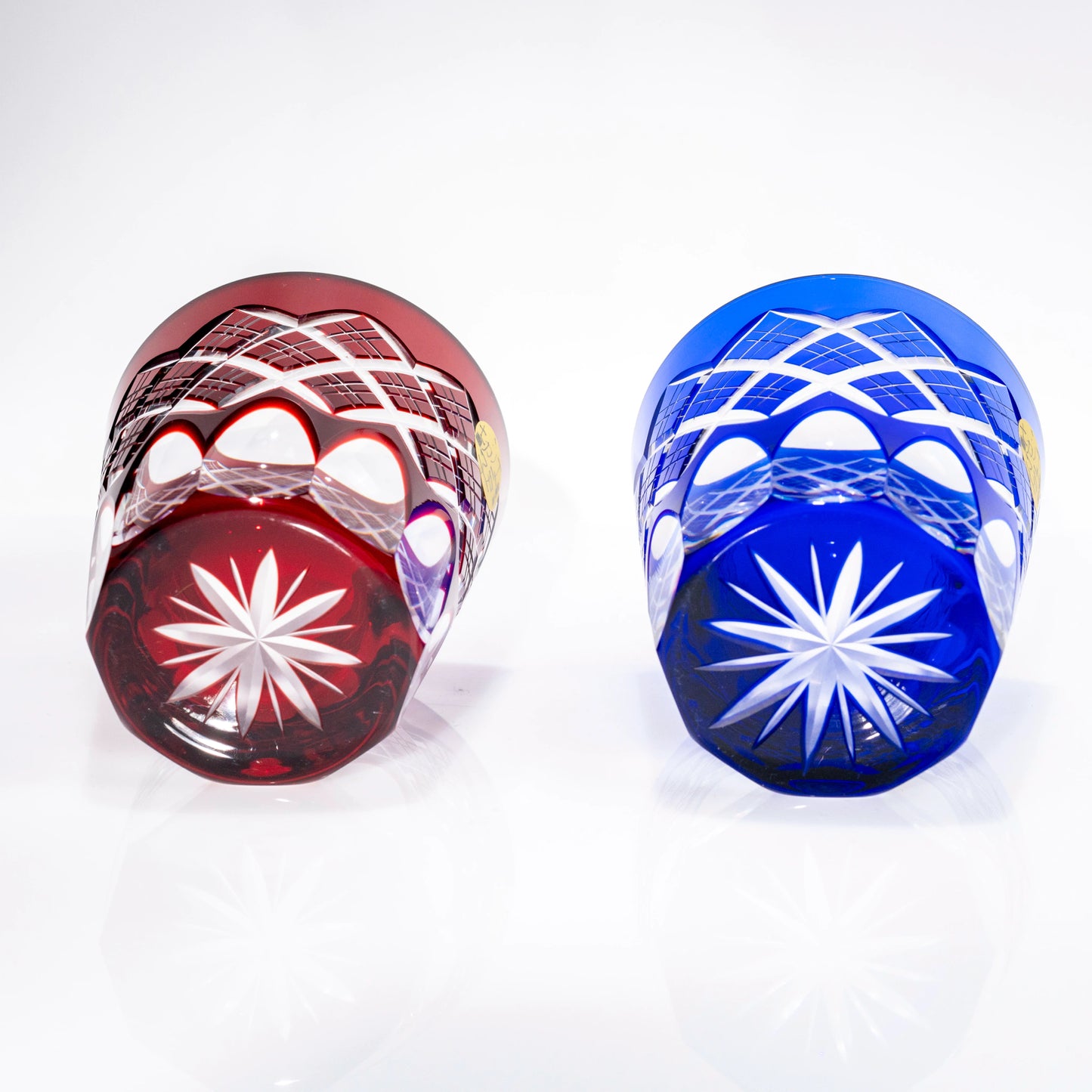 Bottom view of red and blue Edo Kiriko glasses showing star cut bases