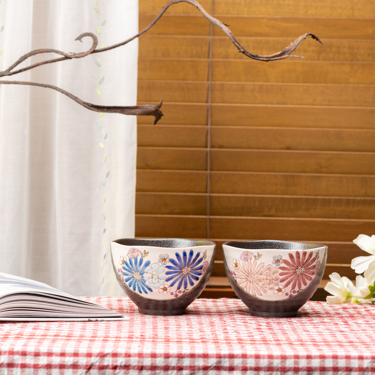 Blue-flower Hana rice bowl beside a matching red-flower bowl on a red gingham tablecloth.