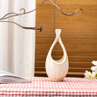 Tall cream-colored Kairo loop vase on a red gingham tablecloth beside a window.
