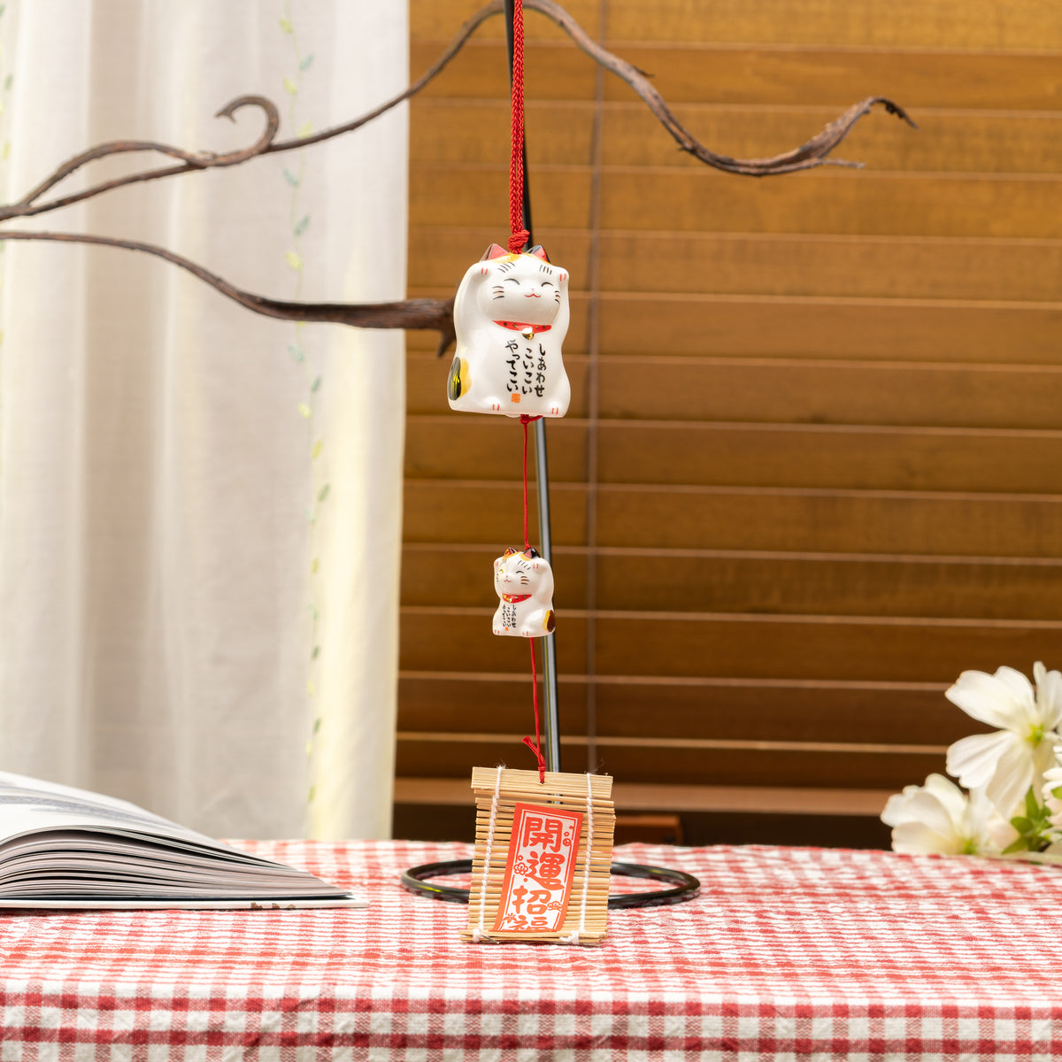 Calico cat and kitten wind chime hanging from a branch, with a bamboo-backed tag below.