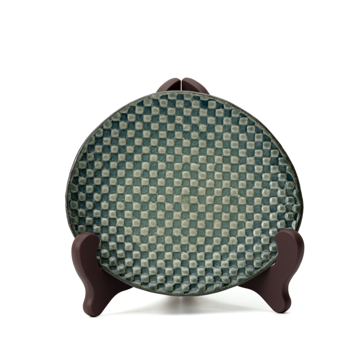 Hechimon Mosaic saucer displayed upright on a stand to show its green checkered pattern.