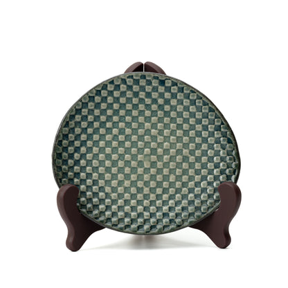 Hechimon Mosaic saucer displayed upright on a stand to show its green checkered pattern.