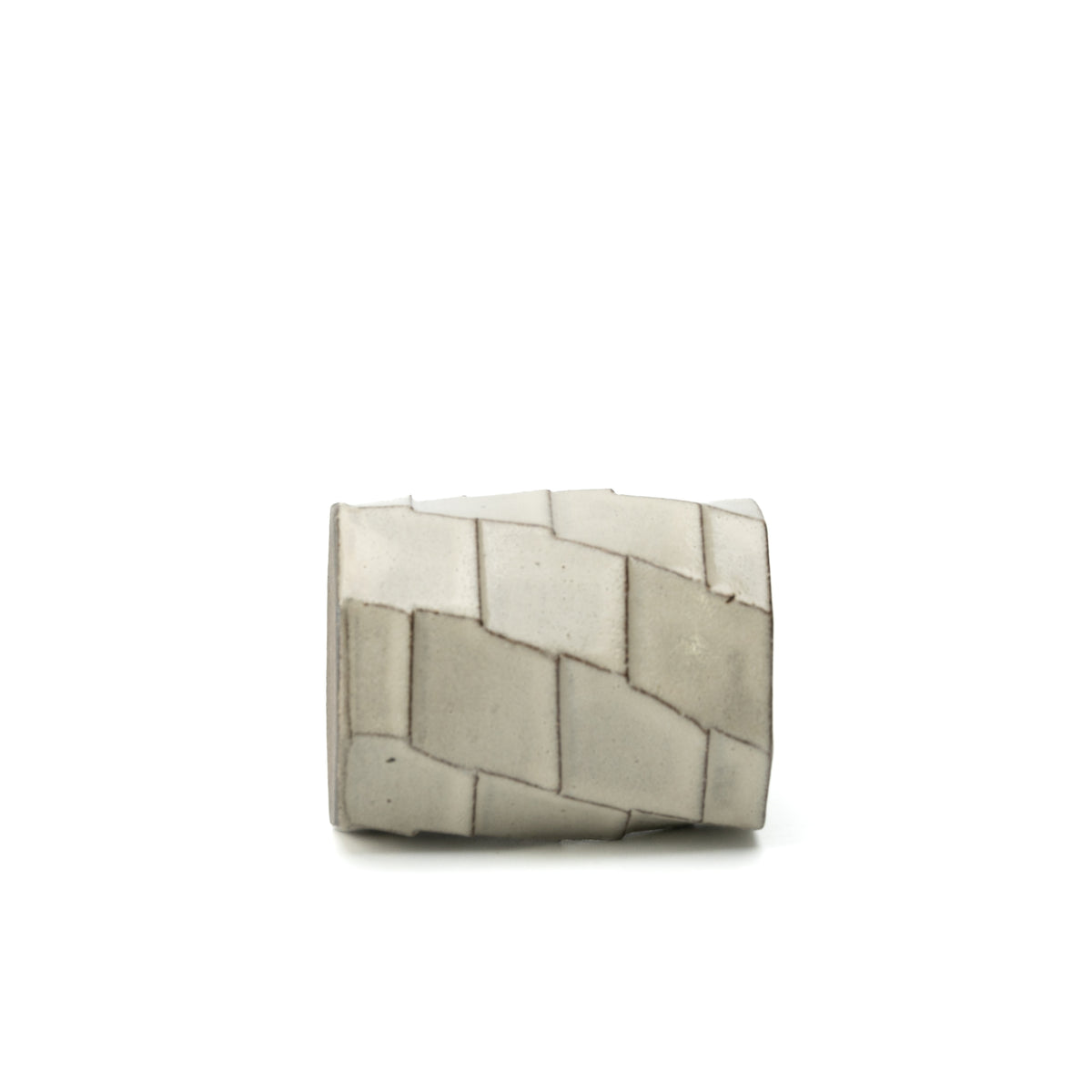 Hechimon Greige mug lying on its side to show the irregular geometric panel pattern.