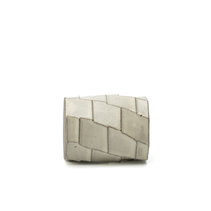 Hechimon Greige mug lying on its side to show the irregular geometric panel pattern.
