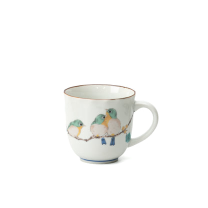 White Mejiro bird mug with three green birds perched on a branch and the handle to the right.