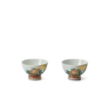 Pair of Kutani sake cups with peony decoration and red-striped feet, shown side by side.