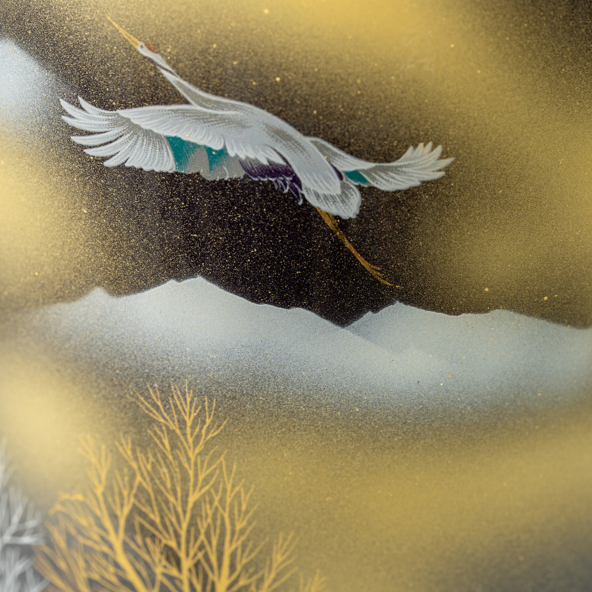 Detail of a flying crane above a pale mountain silhouette on the black-and-gold Kutani vase.