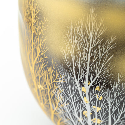 Close-up of fine white and gold-colored tree branches on the crane and woodland vase.