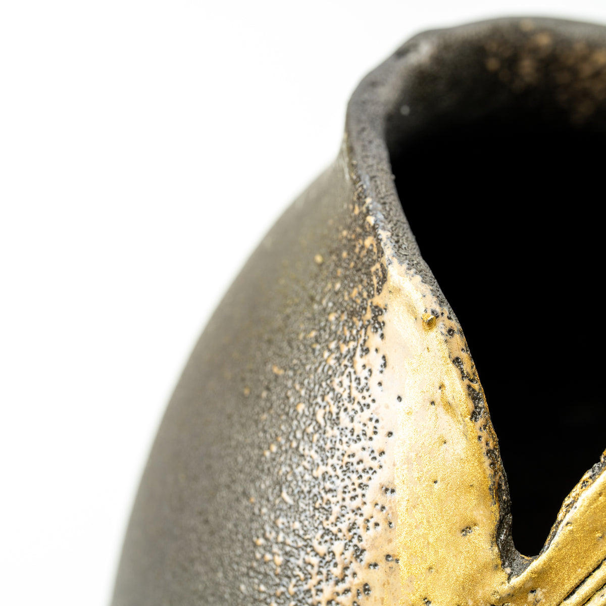 Close-up of the Banju vase's irregular opening and textured dark gray surface with gold-colored glaze.