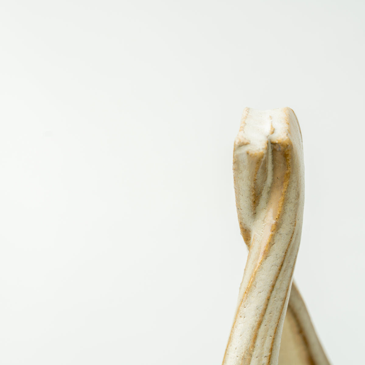 Close-up of the Kairo vase's narrow twisted top and softly textured cream-colored glaze.