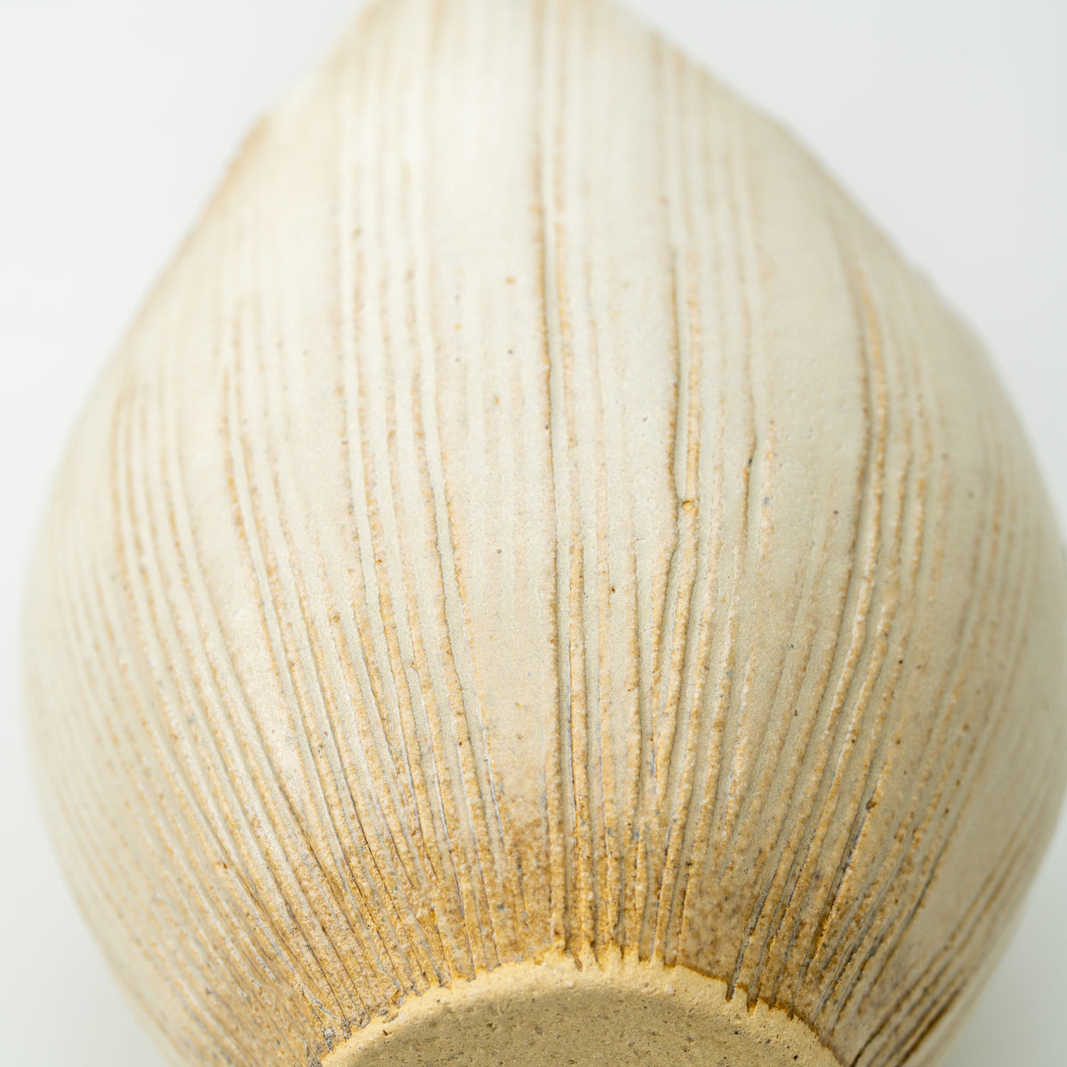 Close-up of the Kairo vase's rounded body, with fine vertical grooves and warm brown accents near the base.
