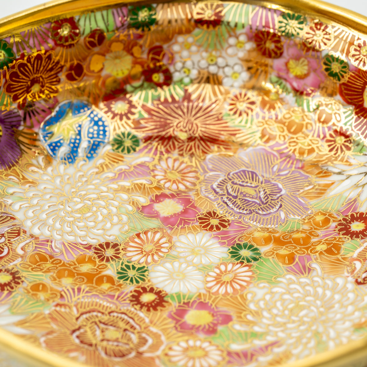 Close-up of the Kinhanazume serving bowl's interior, filled with white, purple, red and blue flowers.