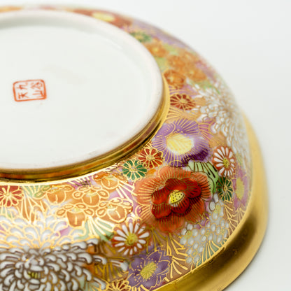 Underside detail of the Kinhanazume serving bowl, showing a red maker's mark surrounded by floral decoration.