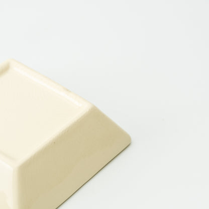 Underside detail of a cream Mino bowl with a raised square foot and smooth sloping side.