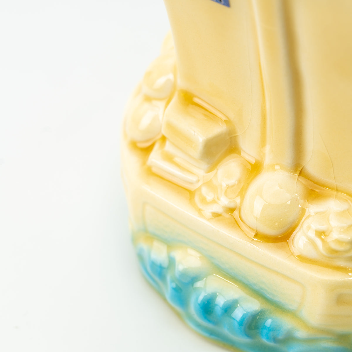 Detail of the treasure ship's yellow side, molded treasures and blue waves along the base.