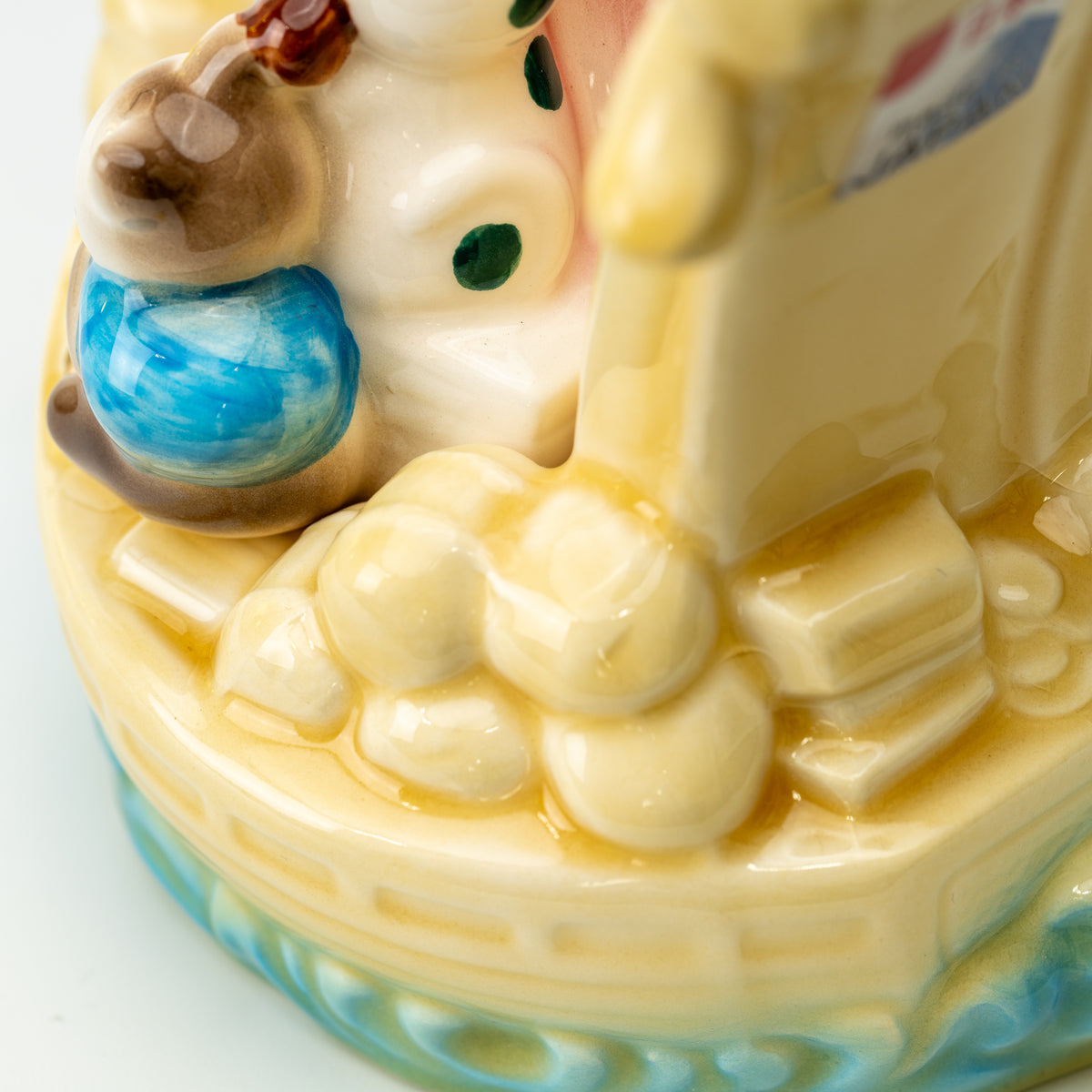 Close-up of molded treasure shapes beside a lucky cat at the corner of the yellow ship.