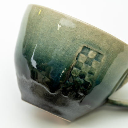 Close-up of the Mosaic cup's checkered panel and the transition from pale green to dark glaze.
