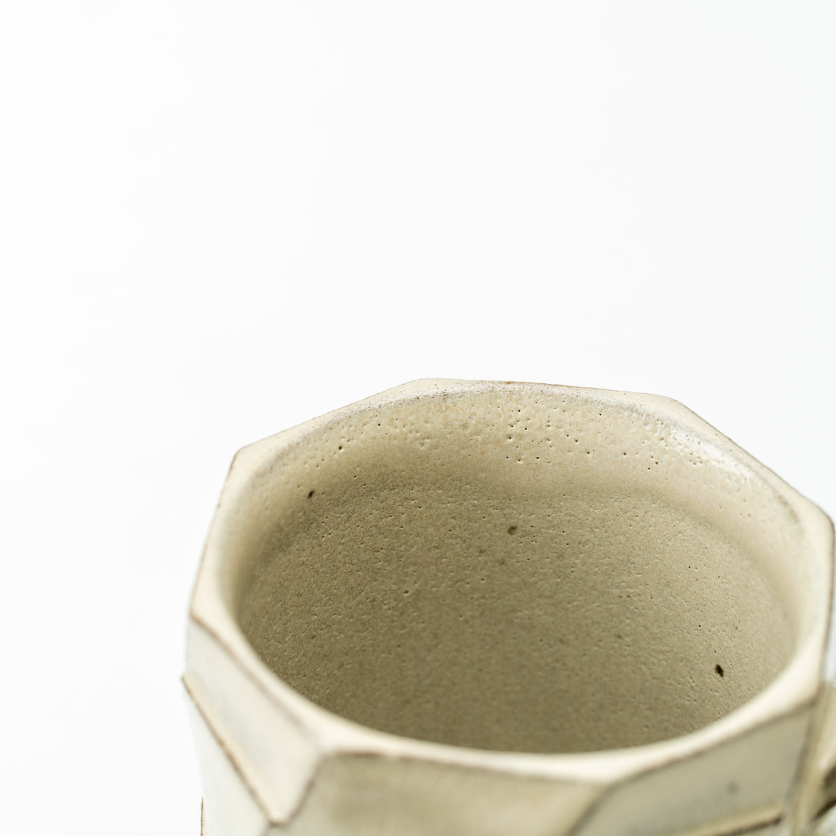 Close-up of the Greige mug's uneven rim and softly speckled beige interior.