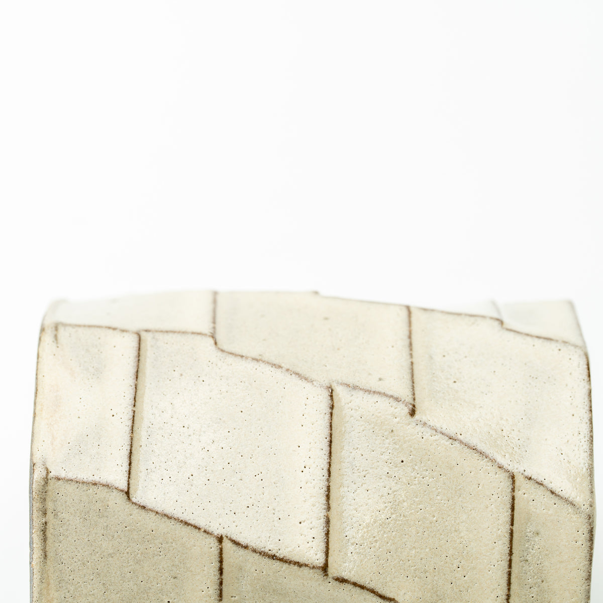 Detail of the Greige mug's pale geometric panels outlined by darker recessed lines.