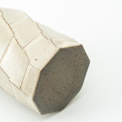Underside of the Hechimon Greige mug showing its dark polygonal base and patterned sides.
