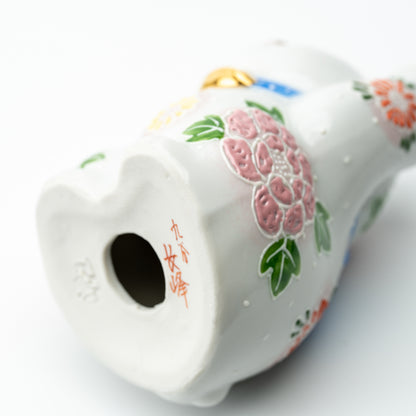 Underside of the Hanazono lucky cat showing the base opening, red markings and floral decoration.